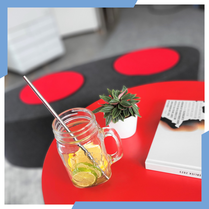 Ein Glas gefüllt mit Limetten und Zitronen, dieses steht auf einem roten Tisch neben einer Pflanze und einem Buch. | © die media GmbH