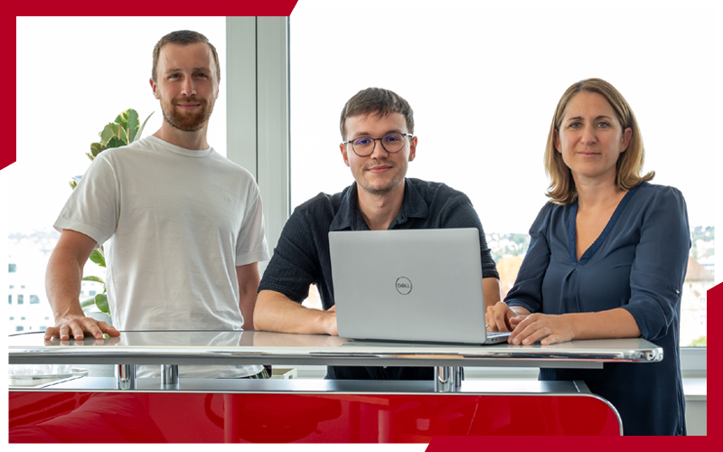Drei Mitarbeiter an einem Hochtisch, vor Ihnen ist ein Laptop. Zusammen bilden sie das Online-Marketing-Team. | © die media GmbH